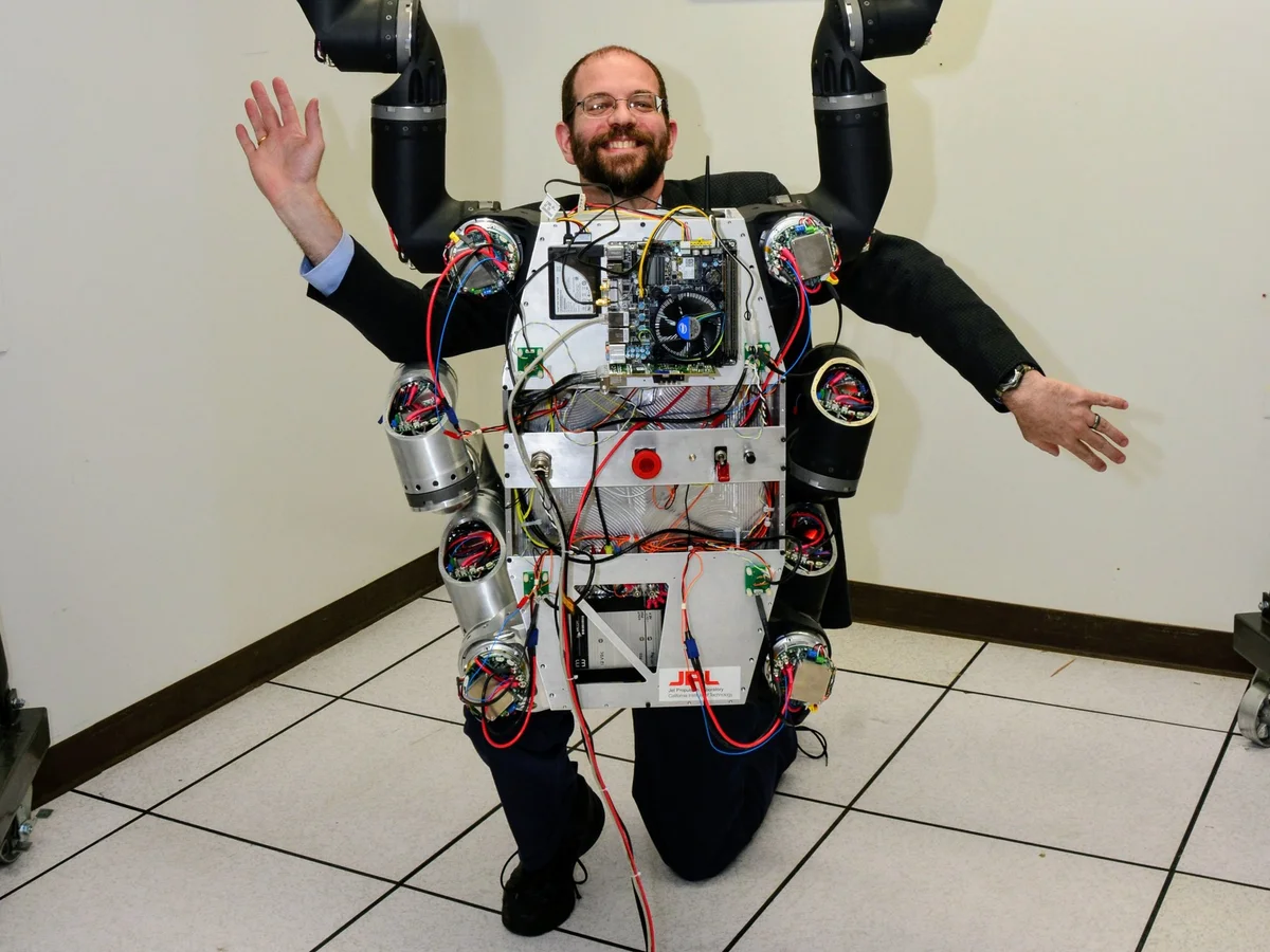 Gill Pratt poses with JPL’s RoboSimian DRC robot